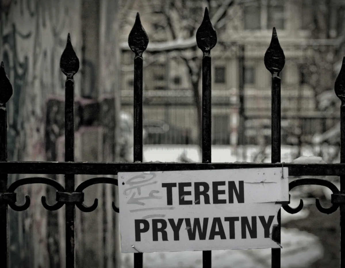 Private property sign fixed to a black iron fence in winter